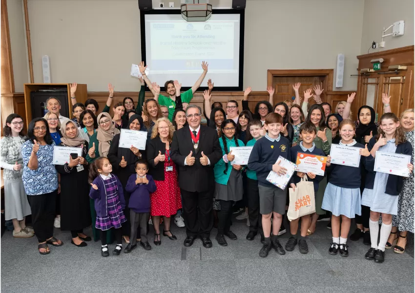 A group photo of the healthy schools celebration with hands in the air, teachers, students and the Deputy Mayor of Barnet