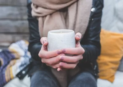 two hands cradling a cup of tea