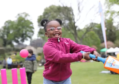 girl swinging cricket bat and smiling