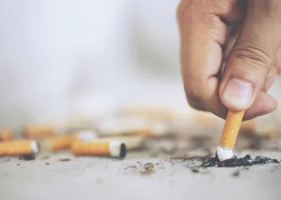 A person's hand as they stub out a cigarette