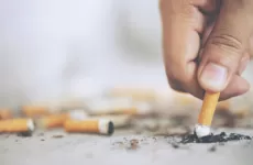 A person's hand as they stub out a cigarette