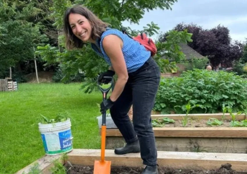 Someone with a spade, digging some soil, at one of the food-growing locations in Barnet.