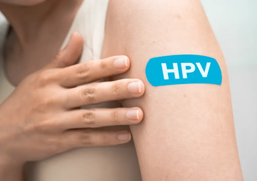 The top of someone's arm, on which there is a plaster with the lettering 'HPV'.