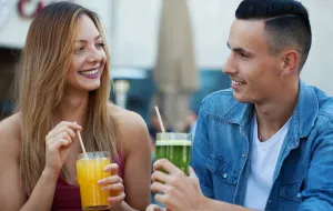 Two people, both holding a drink, smiling.