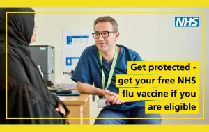 Male nurse wearing blue medical scrubs and leaning on desk, smiling, speaking to female patient wearing grey head covering and smiling. Image has a  yellow border, with black writing on yellow background that says 'get protected - get your free NHS flu vaccine if you are eligible.'