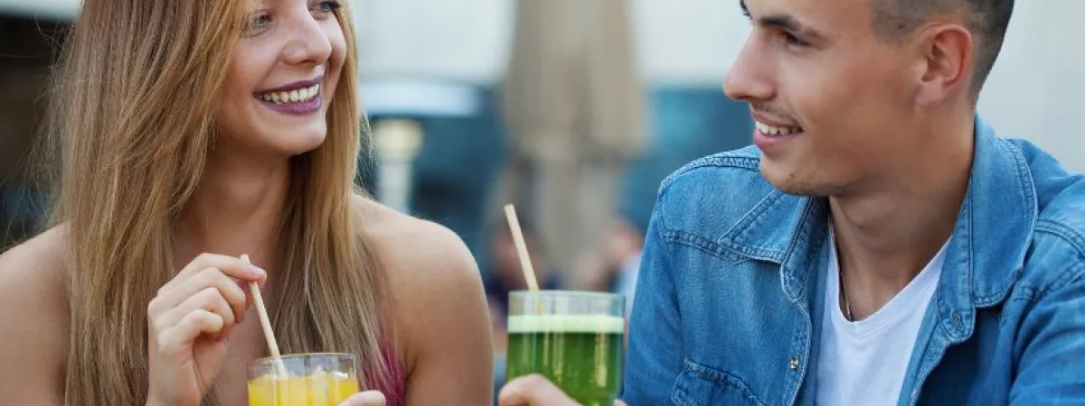 Two people, both holding a drink, smiling.